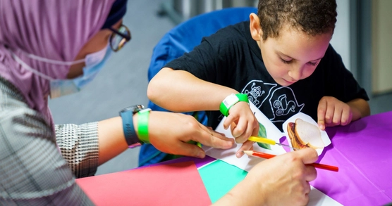 Woman and boy crafting together at a table.