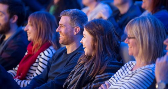 A row of audience members laughing
