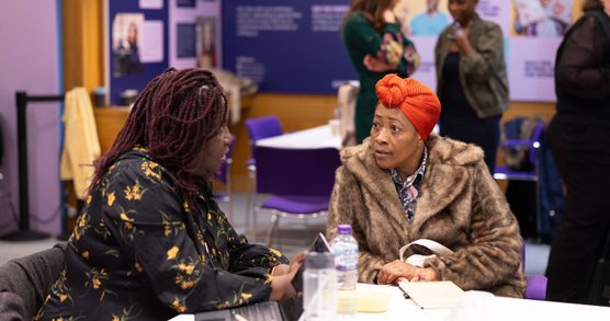 two women talking in a workshop.