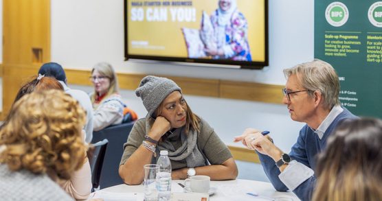 People talking sat at a table in the Business & IP Centre.