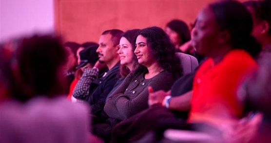 People sat in theatre seating looking at something on stage
