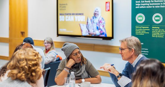 Adults in sat around a round table while participating in a workshop