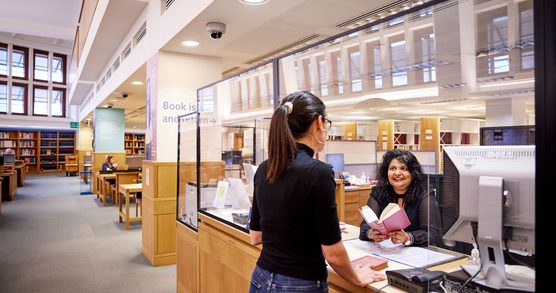 Library visitor at book issue desk.