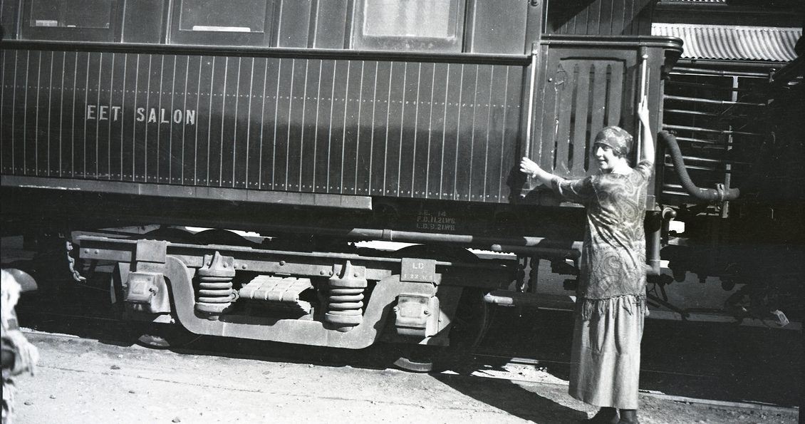 A woman in 1920s attire boarding a train