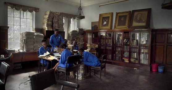 Film still from How to Build a Library which depicts staff sorting through books in a library