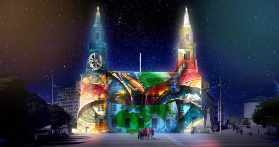 A group of people standing in front of a building with a projection of Earth, hot air balloons, planets and a telescope on its façade.