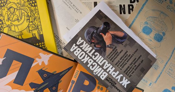 Assorted printed materials in different languages, including illustrated booklets, posters, and pamphlets with military and cultural themes.
