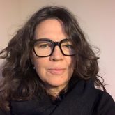 Photo of Jenny Hall, shoulder length dark hair, glasses