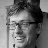 Black and white portrait of a man wearing glasses and smiling