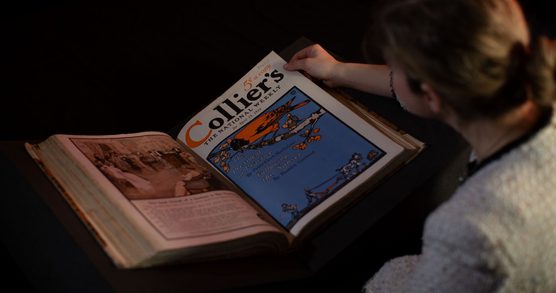Person turning pages of open book
