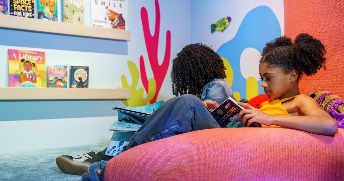 Children reading books in our the reading corner of the Story Explorers exhibition at the British Library