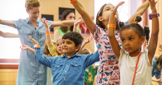 Young children dancing with their arms in the air