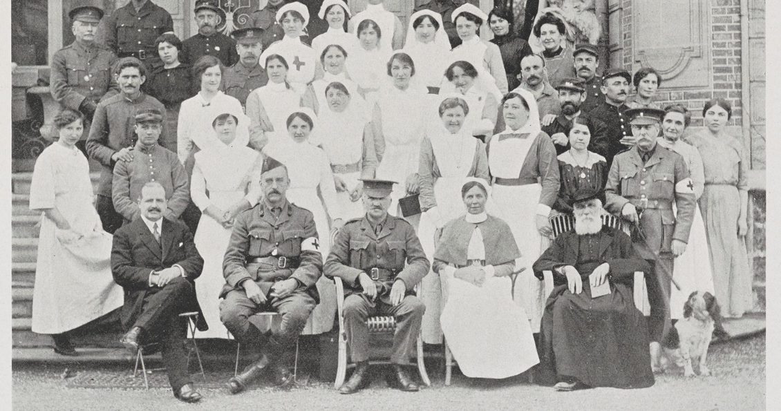 A formal black and white portrait photograph from 1915-1916 showing women in nursing attire and men in military uniform