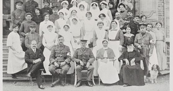 A formal black and white portrait photograph from 1915-1916 showing women in nursing attire and men in military uniform