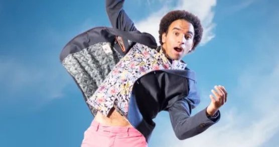 Joseph Coelho jumping against a background of blue sky