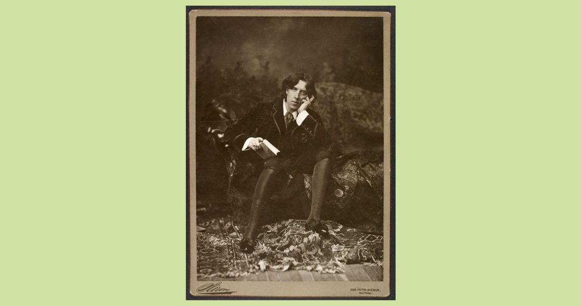 A man seated on a chaise lounge with his head in his hand