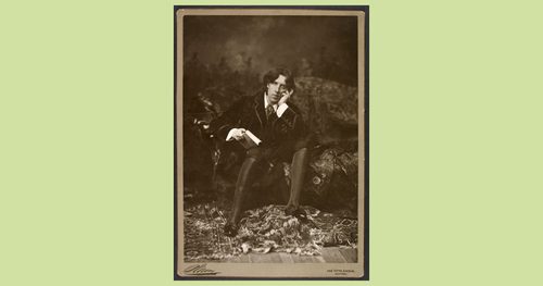 A man seated on a chaise lounge with his head in his hand