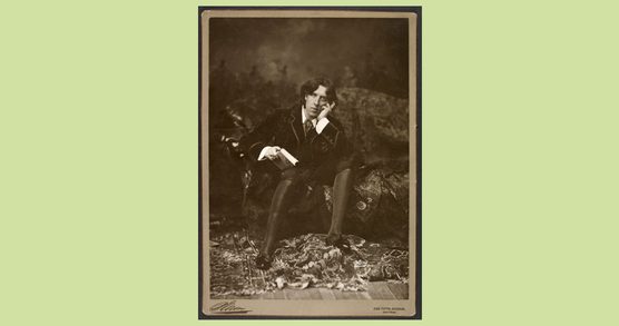 A man seated on a chaise lounge with his head in his hand