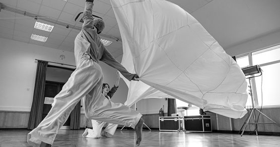two dancers dancing with a parachute