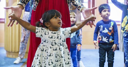 Young girl and carer dance together