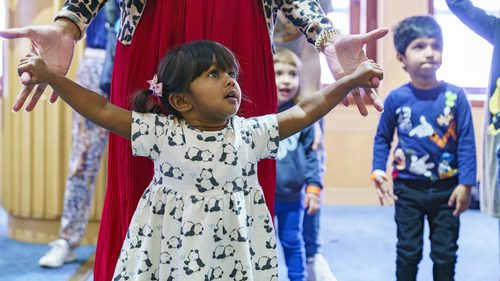 Young girl and carer dance together