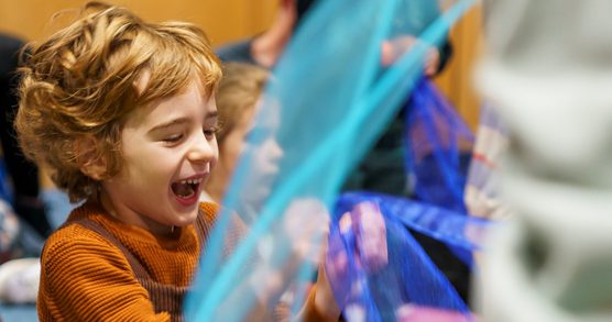 Small boy playing with blue fabric