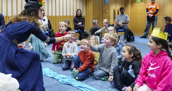 Children watching a storyteller dressed in costume
