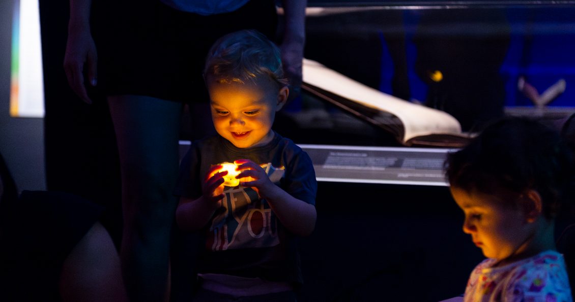 Toddler holding a battery powered tealight candle