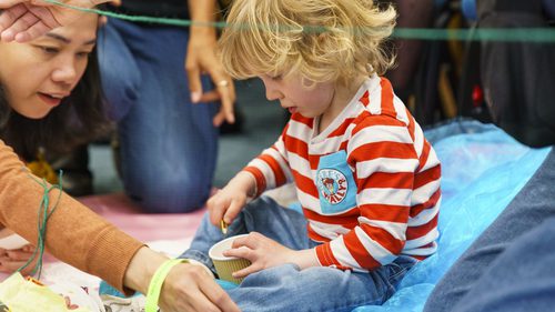 Little boy and a women exploring seeds in a pot