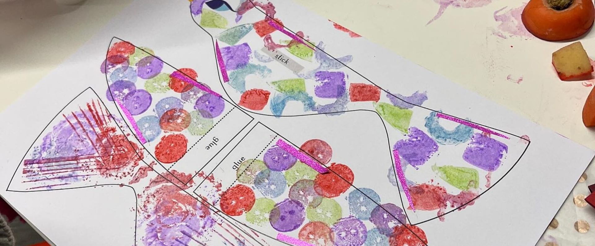 An outline of a bird on paper, block printed with shapes of different colours.