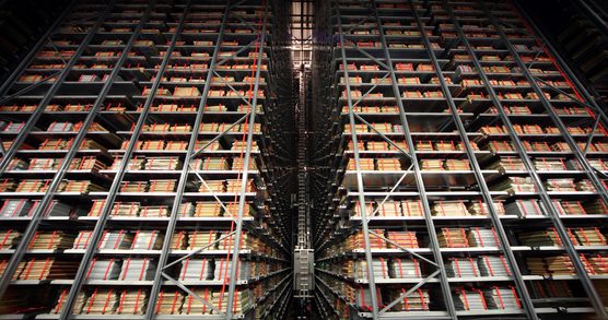 Rows and rows of full shelving, with a robotic crane in the centre.